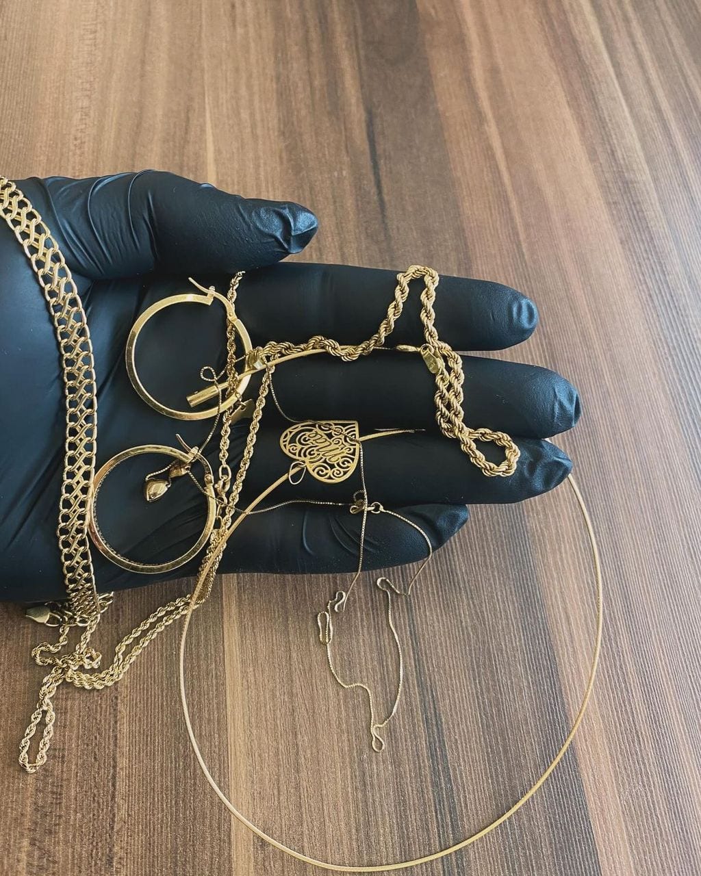 Bijoux en or repris par la maison, présentés dans une main gantée